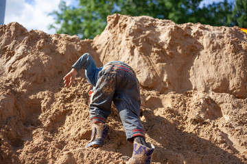 A boy plays in the sandbox.