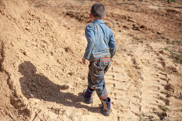 A boy plays in the sandbox.