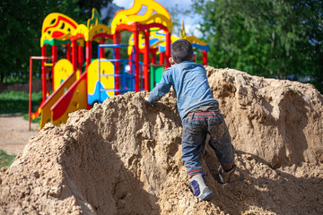 A boy plays in the sandbox.