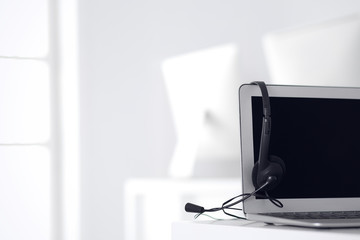 Call center and communication support, customer service help desk. VOIP headset on laptop computer