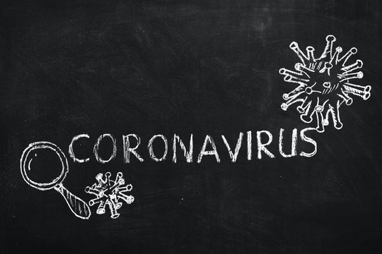 White chalk inscription coronavirus, image of virus SARS-CoV-2, 2019-nCoV, covid-19, acute viral respiratory infection that leads to pneumonia, on blackboard background. World pandemic epidemic.