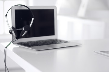 Call center and communication support, customer service help desk. VOIP headset on laptop computer