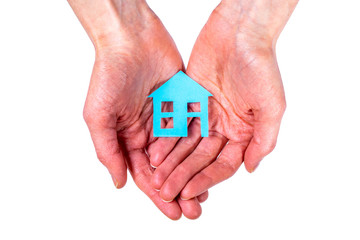 Person holds blue house with both hands isolated on white background