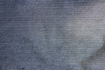 Denim jeans background, faded old weathered texture. Empty jean fabric canvas, washed out light blue faded denim cloth, empty jean material fiber structure, blank copy space for advertising