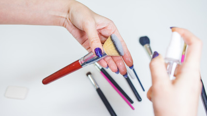 Cleaning and care of makeup brushes, women's hands wash the brush from cosmetics,