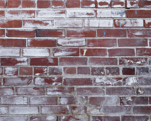 An old red brick wall with chalking paint and small bits of concrete filling entire background photo