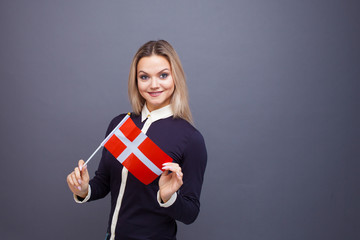 Immigration and the study of foreign languages, concept. A young smiling woman with a Denmark flag...
