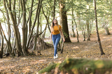 Naklejka na ściany i meble young woman enjoying a walk in the forest