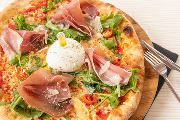 Pizza with mozzarella and raw ham
