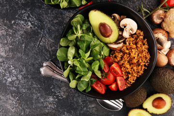 Healthy vegan salad bowl with quinoa, tomatoes, avocado and mixed greens, lettuce. Food and health bowl