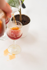 White background, flower in pot, strong black natural coffee in glassware prepared by alternative method from arabica beans.
