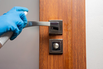 Disinfect and clean door handle with spray and rag, virus spreading prevention