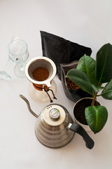 White background, flower in pot, strong black natural coffee in glassware prepared by alternative method from arabica beans.