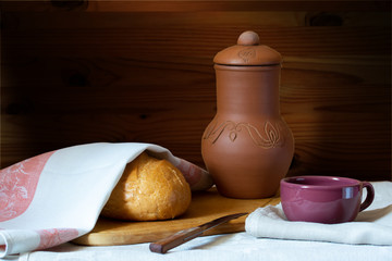 bread and milk jug with milk mug on a wooden background