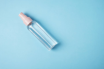 bottle with antiseptic on a blue background with space for text