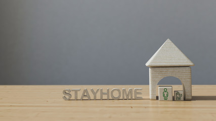 wooden house and the inscription stay home on the table