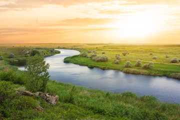river rushing among a hills at the sunset