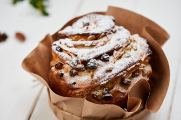Easter cake decorated by raisins and icing sugar on white wooden background, Traditional Kulich, Paska  ready for celebration