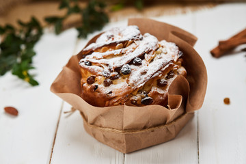 Easter cake decorated by raisins and icing sugar on white wooden background, Traditional Kulich, Paska  ready for celebration