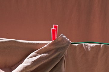 Towels and bed sheets are hanging on a drying rack with colored clothespins (Pesaro, Italy, Europe)
