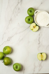 flour and green apples on a white background
