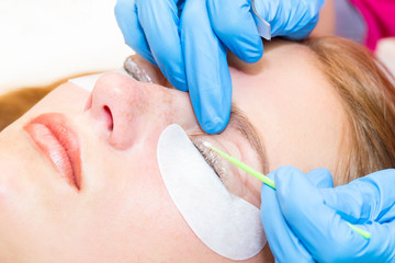 Woman on the procedure for eyelash extensions, eyelashes lamination.