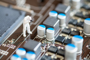 Miniature People: Worker professional checking technology inside old personal computer. maintenance concept, close up view.