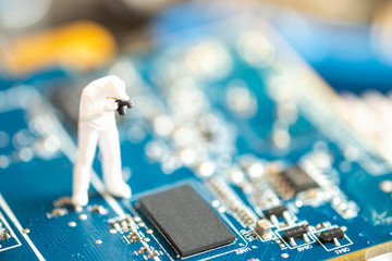 Miniature People: Worker professional checking technology inside old personal computer. maintenance concept, close up view.