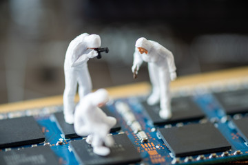 Miniature People: Worker professional checking technology inside old personal computer. maintenance concept, close up view.