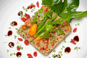 Quinoa salad served vith various vegetables. Healthy and delicious vegetarian meal. Exquisite dish. Creative restaurant meal concept.
