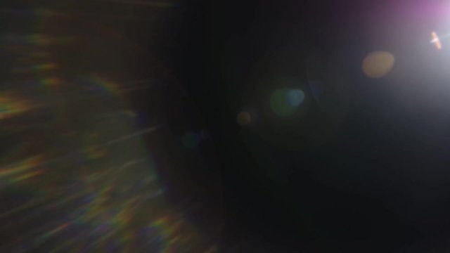 Beautiful abstract defocused lens flare on a dark background. Real light leaks and lens flare.