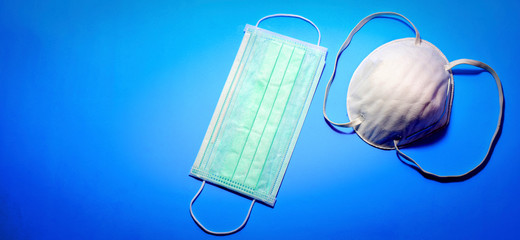 Fototapeta na wymiar Two types of protective face masks on blue background 