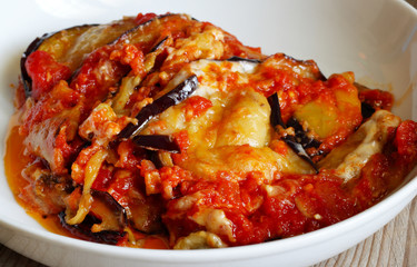 Melanzane alla parmigiana in piatto bianco. Cibo tipico della tradizione siciliana ed in generale del sud Italia. 