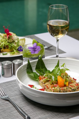 Quinoa salad served vith various vegetables. Healthy and delicious vegetarian meal. Exquisite dish. Creative restaurant meal concept.