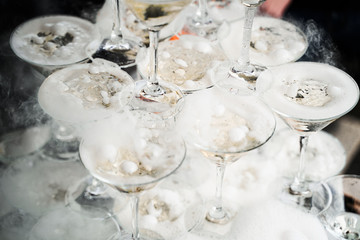 Pyramid with champagne glasses with steam of dry ice.
