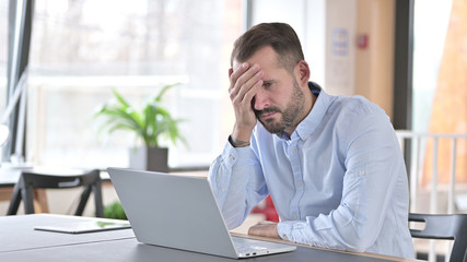 Ashamed Young Man Sitting Disappointed at Work, Loss
