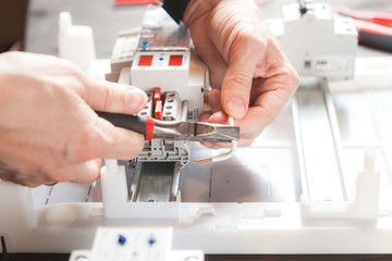 Men's hands close-up. Installation of an electric meter.
