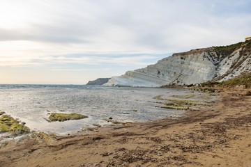 Sandy beach at Scala dei Turchi (Stair of the Turks) near Argigento, Sicily during the beautiful sunset with boulders and green moss