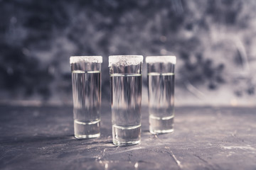 Tequila shots on the dark rustic background. Selective focus. Shallow depth of field.
