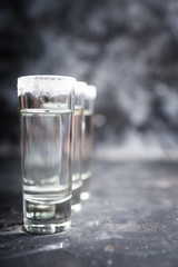 Tequila shots on the dark rustic background. Selective focus. Shallow depth of field.
