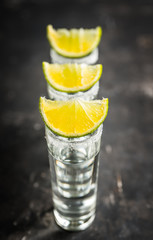 Tequila shots on the dark rustic background. Selective focus. Shallow depth of field.
