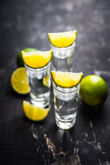 Tequila shots on the dark rustic background. Selective focus. Shallow depth of field.
