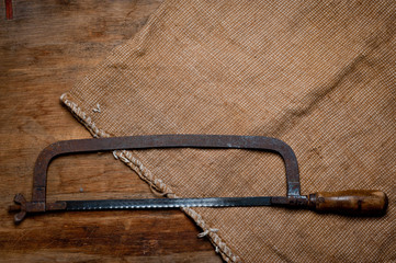 Old vintage metal hacksaw of the last century extracted from the chest in the workshop of grandfather. Background for craftsmanship and manual labor.
