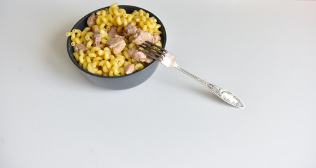 boiled macaroni with meat on a plate on a white background