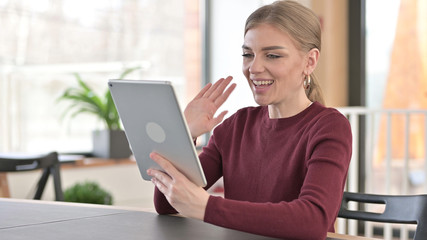 Online Video Chat on Tablet by Young Woman in Office