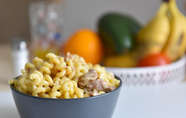 boiled macaroni with meat on a plate on a white background