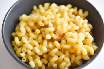 boiled macaroni with meat on a plate on a white background
