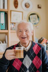 Old man drinking coffee at home