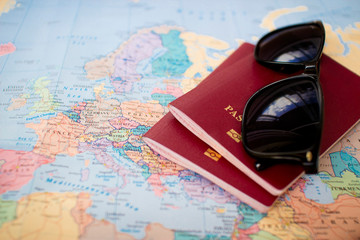 Fototapeta na wymiar two red passports and sunglasses on the world europe map. travel planning, permission and visa concept