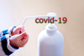 赤ちゃんの手と消毒用ボトルとCOVID-19の文字とコピースペース